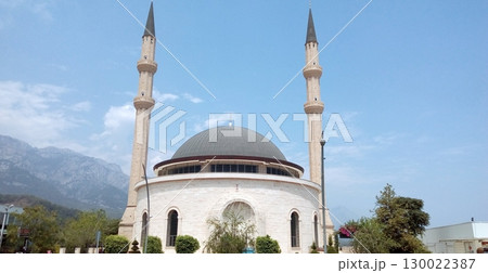 A Majestic Mosque with Two Minarets Against a Scenic Mountain Backdrop Under Blue Sky 130022387