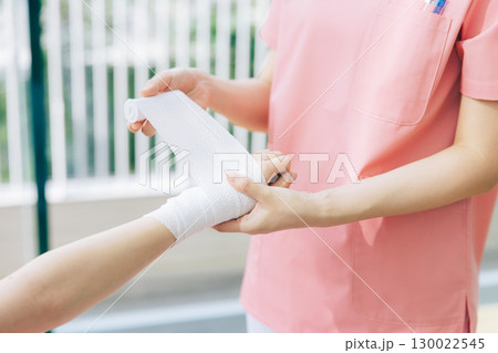 包帯を巻く女性看護師 包帯を巻く女性看護師 130022545