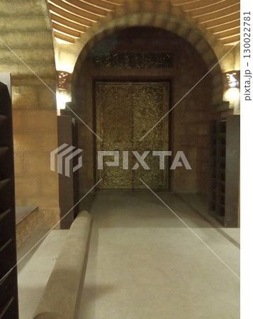 Golden Ornate Doorway Under an Arched Stone Entrance with Warm Lighting 130022781