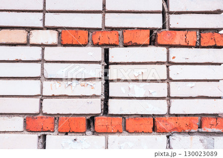 Textured texture of white and red brick.Cracked old brick wall. Brick close-up. 130023089