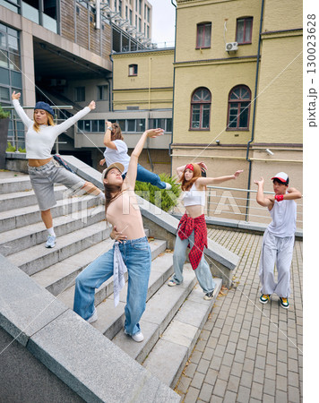 Group of urban dancers posing on stairs with dramatic gestures and stylish energy Group of urban dancers posing on stairs with dramatic gestures and stylish energy 130023628