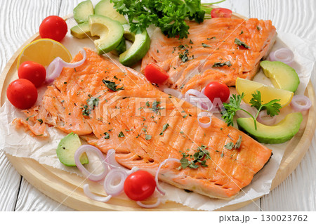 grilled salmon fillet on circle wooden board 130023762