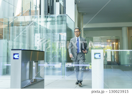 オフィスのエントランスを歩くスーツを着たビジネスマン　撮影協力:スカパー東京メディアセンター 130023915
