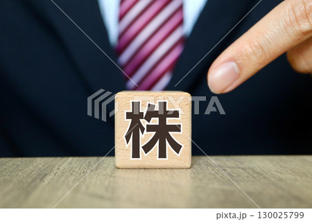 株と書かれた木製ブロックとスーツ姿のビジネスマン 130025799