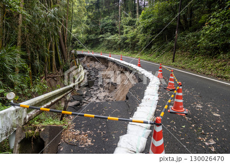 大雨の被害でアスファルトの道路が崩れている 130026470