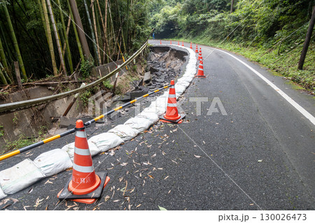 大雨の被害でアスファルトの道路が崩れている 130026473