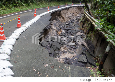大雨の被害でアスファルトの道路が崩れている 130026477