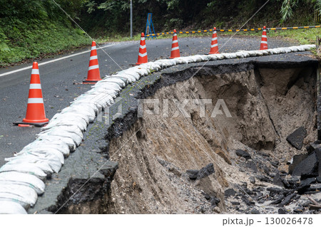 大雨の被害でアスファルトの道路が崩れている 130026478