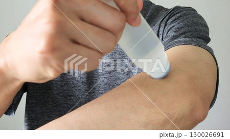 腕に湿布を塗る人物 130026691