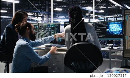 Data center software developers using machine learning algorithms to analyze large datasets. Server hub IT experts cooperating, using AI neural networks to recognize data patterns, camera A 130027315