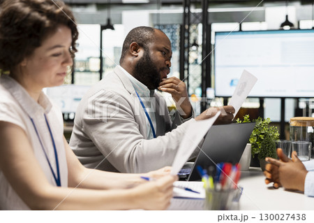 Diverse HR interviewers meeting with an applicant to review CV document, focusing on talent acquisition, work experience and qualifications for employment and onboarding process in enterprise. 130027438