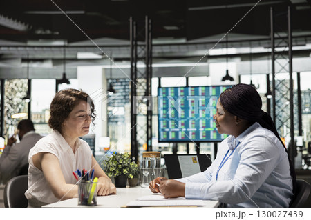 Hiring manager conducting a detailed job interview with applicant, reviewing the candidate qualifications, CV resume and potential onboarding for career advancement within the company. Hiring manager conducting a detailed job interview with applicant, reviewing the candidate qualifications, CV resume and potential onboarding for career advancement within the company. 130027439