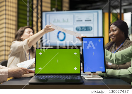 Diverse business associates using isolated display in modern office session, supporting digital planning and studying performance data reports. Strategic thinking and determination. Diverse business associates using isolated display in modern office session, supporting digital planning and studying performance data reports. Strategic thinking and determination. 130027487