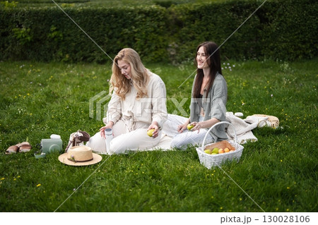 Enjoying a sunny afternoon picnic with friends in a green park 130028106