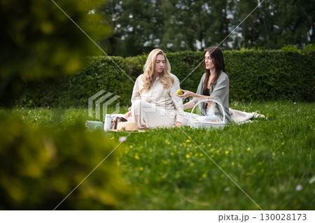 Enjoying a delightful picnic in a lush garden on a sunny afternoon 130028173