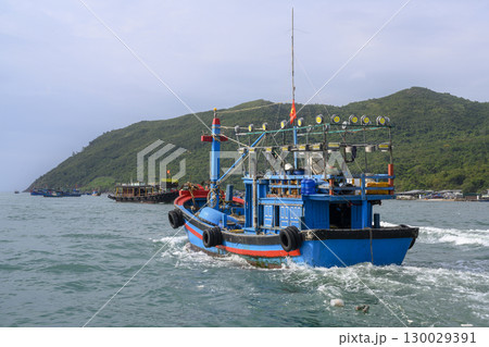 Fishing boat near a mountainous island in the South China Sea near Nha Trang, Vietnam Fishing boat near a mountainous island in the South China Sea near Nha Trang, Vietnam 130029391