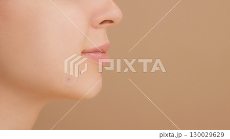 Close-up of a young woman applies a round acne patch to a blemish for spot treatment. Acne treatment, zit patch, acne spot patch ads. Young girl and smile in studio on beige background. Copy space Close-up of a young woman applies a round acne patch to a blemish for spot treatment. Acne treatment, zit patch, acne spot patch ads. Young girl and smile in studio on beige background. Copy space 130029629