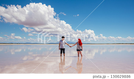 鏡のような塩湖で手をつなぐ二人 130029886