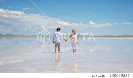 鏡のような塩湖で手をつなぐ二人 130029887