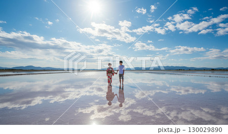 鏡のような塩湖で手をつなぐ二人 130029890