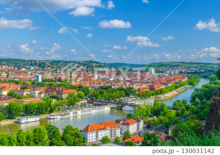 Aerial panoramic view of Wurzburg city historical center with Ludwig Bridge, Main river with touristic ships and green hills background on horizon, Lower Franconia region, Bavaria state, Germany 130031142