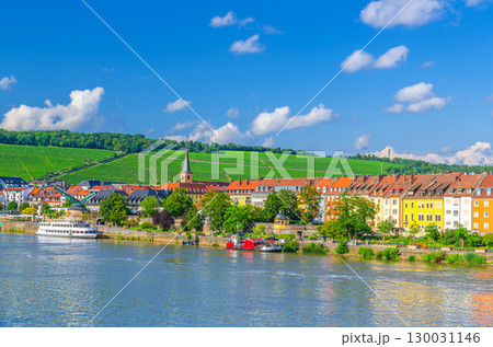 Wurzburg old town altstadt with old colorful houses on Main river embankment in Wurzburg city historical center Mitte, vineyards on green hill background in sunny summer day, Bavaria state, Germany 130031146