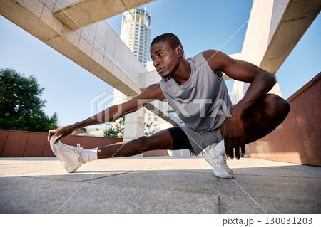 Athlete stretching in a modern architectural urban environment Athlete stretching in a modern architectural urban environment 130031203