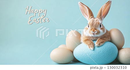 Cute bunny sitting on blue egg surrounded by eggs celebrating Easter holiday  130032310