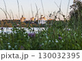 Sun is setting by the lake with city buildings and church on the background 130032395