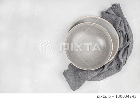 Empty gray ceramic plates with linen napkin on white textured background. top view. copy space Empty gray ceramic plates with linen napkin on white textured background. top view. copy space 130034243