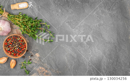 Fresh herbs garlic pepper and sea salt on dark stone background. top view. copy space 130034256