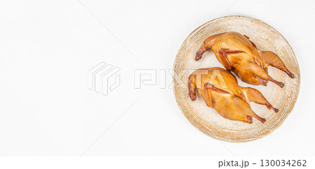 Two smoked quails on rustic plate from eco farm. top view. copy space 130034262
