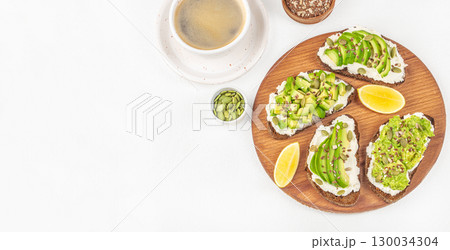 Avocado toast with seeds and coffee on white background, healthy breakfast concept, Long banner format. top view. copy space Avocado toast with seeds and coffee on white background, healthy breakfast concept, Long banner format. top view. copy space 130034304