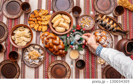 Traditional Ukrainian Christmas Eve table with twelve festive dishes and holiday decorations, top view Traditional Ukrainian Christmas Eve table with twelve festive dishes and holiday decorations, top view 130034305
