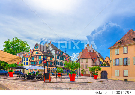 Old houses half-timbered style colorful facade medieval buildings multicolored walls and street restaurants on small square in old town Colmar city historic centre, Alsace Grand Est region, France 130034797
