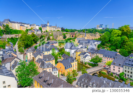 Luxembourg City historic centre aerial panoramic view, old colorful buildings and green trees, Luxembourg cityscape skyline horizon with blue sky, Luxembourg old town Grund and Ville Haute districts 130035346