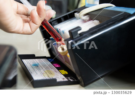 Top view of printer filling with yellow ink. Top view of printer filling with yellow ink. 130035629
