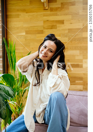 Portrait of smiling woman enjoying a peaceful moment at home 130035766