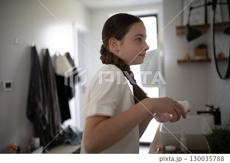 Teenager treating acne, taking care of her skin at home. 130035788