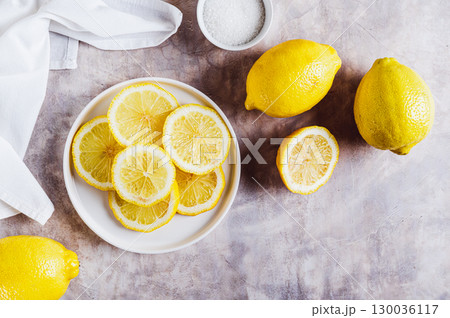 Fresh ripe sliced lemon on a plate on the table top view 130036117