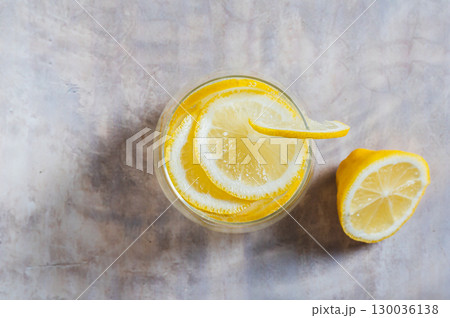 Close up of refreshing lemon water in a glass on the table top view Close up of refreshing lemon water in a glass on the table top view 130036138