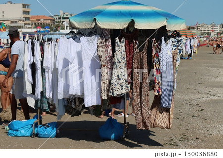 Vendor selling colorful summer clothes on a beach stall 130036880
