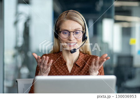 Confident businesswoman with glasses and headset participates in a video call, exemplifying remote collaboration and effective communication within a professional work environment. Confident businesswoman with glasses and headset participates in a video call, exemplifying remote collaboration and effective communication within a professional work environment. 130036953