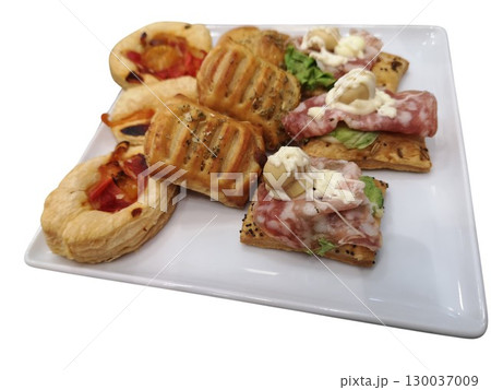 Delicious savory pastries with various toppings on white plate Delicious savory pastries with various toppings on white plate 130037009