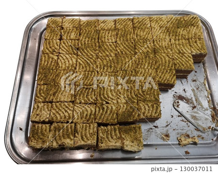 Pistachio cake slices arranged on metal tray for catering event 130037011
