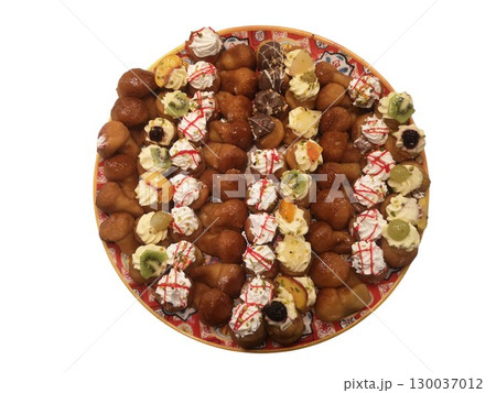 Rum baba cakes with cream and fruit garnishing filling a serving dish 130037012
