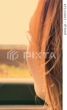 Happy girl smiling by the car window, Joyful woman on a road trip, Young woman enjoying travel scenery, Sunshine on her face as she travels, Lady finds happiness on the open road, Human connection 130037124