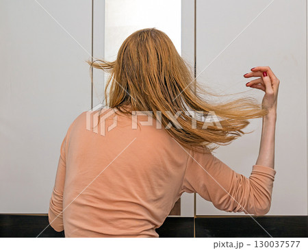 Woman gixing her hair Woman gixing her hair 130037577