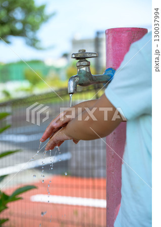 公園の蛇口で手を洗う幼稚園児 130037994