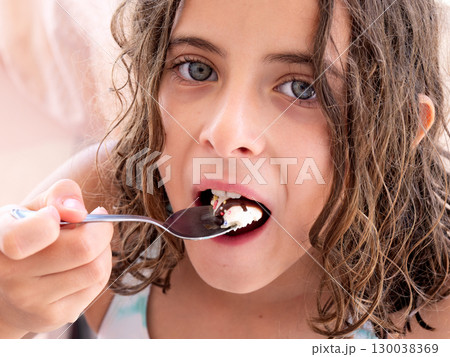 Happy Girl Enjoying Delicious Ice Cream with Colorful Sprinkles Happy Girl Enjoying Delicious Ice Cream with Colorful Sprinkles 130038369